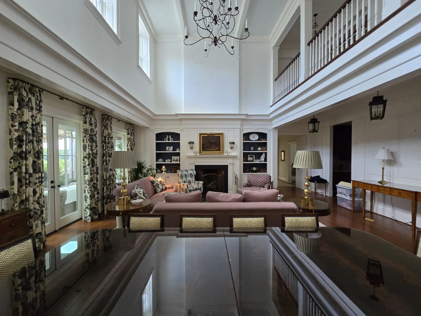 Bright two-story living room with white trim and chandelier — Alvarez' Painting in Charlottesville
